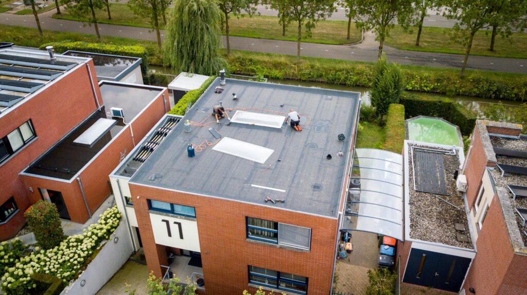 Dakwerkzaamheden aan een plat dak, gezien vanuit de lucht